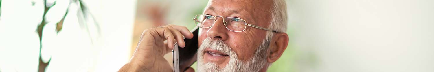 An older man speaking on a cell phone with Standard Heating, Cooling & Plumbing