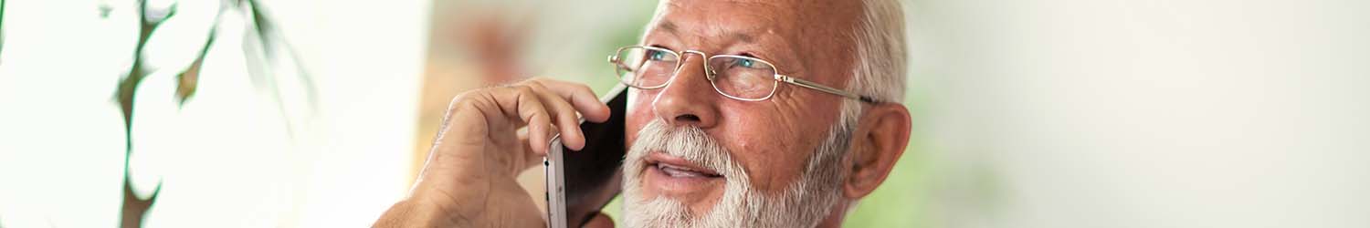 An older man speaking on a cell phone and asking about heat pump repair