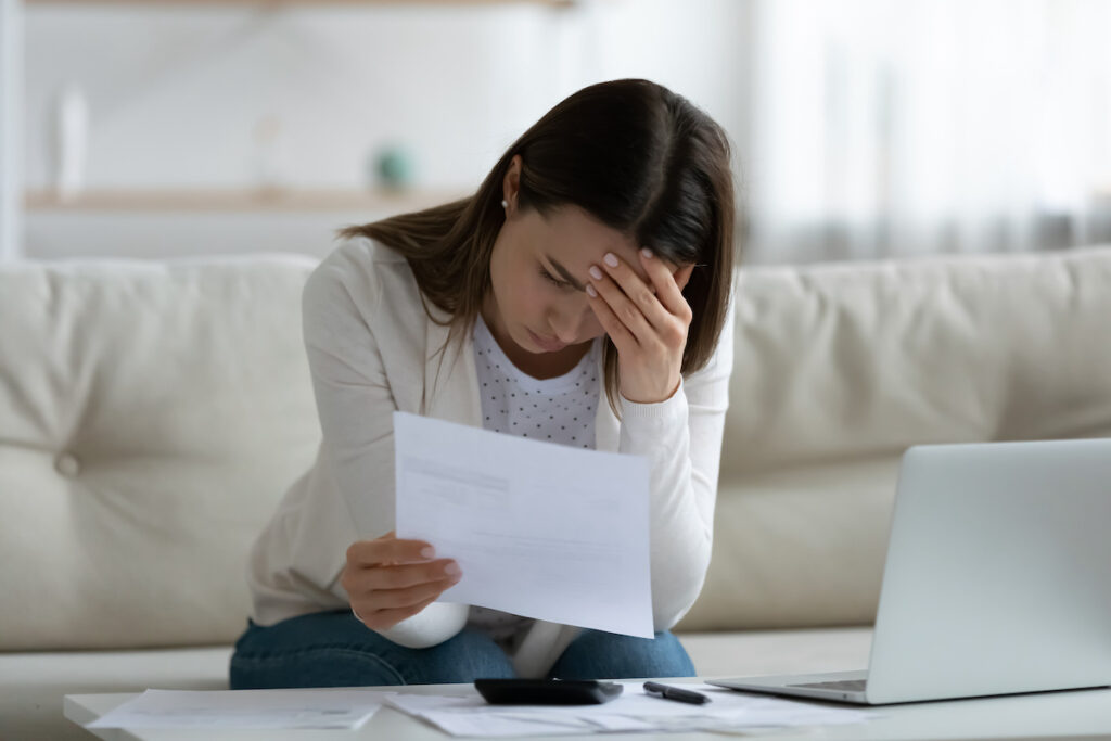 Woman read bad news notification letter from bank about debt